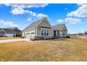 Attractive house featuring a three-car garage, stone details, and a spacious lawn at 16544 Gaither Ct, Westfield, IN 46074