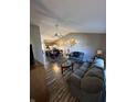 Spacious living room with hardwood floors, ceiling fan and a view into the kitchen and dining areas at 1755 N Wellesley Commons, Indianapolis, IN 46219
