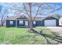 Inviting one-story house boasts mature landscaping and a convenient attached garage at 1755 Pinion Ct, Columbus, IN 47201