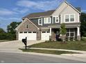 Charming two-story home boasts a brick and siding exterior, three-car garage and a well-maintained lawn at 3535 Merchmont Rd, Bargersville, IN 46106