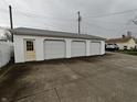 A detached three-car garage features white siding, offering ample parking and storage at 367 W Broadway St, Shelbyville, IN 46176