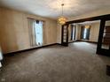 Open-concept living room with decorative lighting, neutral carpet, and elegant entryway at 367 W Broadway St, Shelbyville, IN 46176