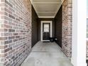 Covered front entry with brick columns and a black front door with glass at 3865 Kensington Dr, Danville, IN 46122