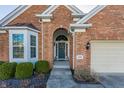 Inviting front entrance with a wreath-adorned door, brick facade, and manicured landscaping at 405 Letterman Dr, Brownsburg, IN 46112