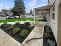 Covered front porch with a patterned walkway, lush landscaping, and manicured hedges at 447 S Bradley Ave, Indianapolis, IN 46201