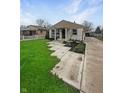 Inviting single-story home with well-kept lawn, patterned walkway, and lush landscaping at 447 S Bradley Ave, Indianapolis, IN 46201