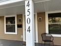 Inviting front porch with house number, chair, and black mailbox and sconces at 4504 Winthrop Ave, Indianapolis, IN 46205