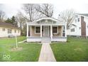 Well-maintained front yard showcasing a charming home with a covered front porch at 4504 Winthrop Ave, Indianapolis, IN 46205