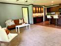 Comfortable living room with natural light, neutral carpet, and dark trim flows into the kitchen bar area at 5010 S 550 W, Columbus, IN 47201