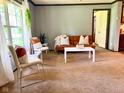 Sun-filled living room with neutral carpet, modern furnishings, and soft, natural light from a nearby window at 5010 S 550 W, Columbus, IN 47201