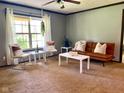 Sun-filled living room with neutral carpet, modern furnishings, and soft, natural light from a nearby window at 5010 S 550 W, Columbus, IN 47201