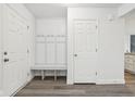 Mud room with white trim, bench, and coat hooks adjacent to interior door and wood look floors at 5520 N Woodside Ct, McCordsville, IN 46055