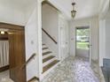 Bright foyer with mosaic tile flooring, staircase, and front door at 569 King Dr, Indianapolis, IN 46260