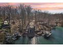 Waterfront home surrounded by trees with a private dock and boat lift for enjoying lake activities and peaceful sunsets at 6198 Grosbeak Dr, Nineveh, IN 46164