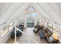 Bright living room with vaulted ceilings, large windows, and a sliding door to a deck with lake views at 6198 Grosbeak Dr, Nineveh, IN 46164