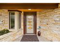 Welcoming entryway with diamond-patterned door, stone walls, and charming decor with accent window at 6461 Sunset Ln, Indianapolis, IN 46260