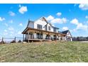 Beautiful farmhouse with a wrap-around porch featuring comfortable seating areas and scenic views at 7418 W Old Sr 252, Edinburgh, IN 46124