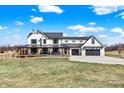 Inviting farmhouse with a covered porch, rocking chairs, and a two-car garage at 7418 W Old Sr 252, Edinburgh, IN 46124