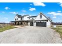 Charming farmhouse with a covered porch, rocking chairs, and a two-car garage at 7418 W Old Sr 252, Edinburgh, IN 46124