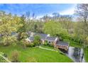 Stunning aerial view of a brick home with lush landscaping, mature trees, and a well-manicured lawn at 8510 N Park Ave, Indianapolis, IN 46240