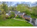 Attractive aerial view of a brick home showcasing well-maintained landscaping and surrounding greenery for a private setting at 8510 N Park Ave, Indianapolis, IN 46240