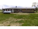 Picture of the backyard of the single-story home with a metal roof and a propane tank at 10966 W State Road 142, Quincy, IN 47456