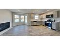 Open kitchen featuring modern cabinets, stainless appliances, an eat-in area with fireplace and outdoor access at 11144 Echo Trl, Indianapolis, IN 46236