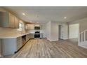 Modern kitchen featuring stainless appliances, light gray cabinetry, and hardwood floors at 11144 Echo Trl, Indianapolis, IN 46236