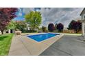 A private in-ground pool is surrounded by a concrete patio and a lush landscaped yard with mature trees at 11144 Echo Trl, Indianapolis, IN 46236