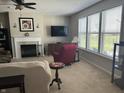 Comfortable living room featuring a fireplace, large windows, and plush seating, perfect for relaxation at 1460 Tuscany Dr, Greenwood, IN 46143