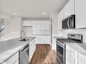 Bright, modern kitchen featuring white cabinets, stainless steel appliances, and a gray countertop at 16429 Mount Logan Rd, Noblesville, IN 46060