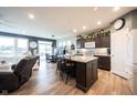 Open-concept kitchen with dark cabinets, light countertops, large island with seating, and modern appliances at 19252 Chestnut Grove Ln, Noblesville, IN 46062