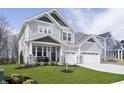 Charming two-story home featuring gray siding, stone accents, a well-manicured lawn, and a three-car garage at 19966 Chatham Green Dr, Westfield, IN 46074