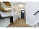 Elegant foyer featuring stylish decor, hardwood floors, and a striking black front door at 19966 Chatham Green Dr, Westfield, IN 46074