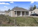 Cozy one-story house with a covered front porch, light-colored siding, and a partially fenced yard in a residential neighborhood at 3022 Alice Ave, Indianapolis, IN 46237