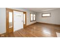 Bright living room with hardwood floors, natural light, and detailed wood trim around the doorway at 415 Ruskin Pl, Indianapolis, IN 46205