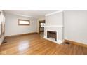 Open living room featuring a decorative fireplace, hardwood floors, and freshly painted walls at 415 Ruskin Pl, Indianapolis, IN 46205