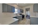 Contemporary kitchen boasts gray cabinets, stainless steel appliances, and stylish tile flooring at 5467 Powder River Ct, Indianapolis, IN 46221