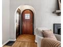 Inviting entryway featuring hardwood floors, an arched doorway, and a cozy chair with a throw at 5534 Guilford Ave, Indianapolis, IN 46220