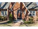 Close-up of a brick home's arched entryway with beautiful landscaping and a brick pathway at 5534 Guilford Ave, Indianapolis, IN 46220