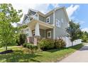 Charming two-story home with a covered porch and landscaped side yard and green horizontal siding at 5944 Aldridge Dr, Whitestown, IN 46075
