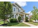 Charming two-story home with a covered porch and landscaped front yard and green horizontal siding at 5944 Aldridge Dr, Whitestown, IN 46075
