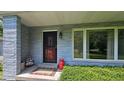 Inviting front porch with unique door decor, colorful accents, and well-kept landscaping at 6040 W Thompson Rd, Indianapolis, IN 46221