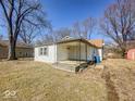 View of a cozy one-story home with a covered porch and a small yard, showcasing its quaint appeal at 6616 W Thompson Rd, Indianapolis, IN 46241