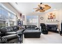 Spacious living room with a ceiling fan, large windows, and fireplace at 7236 Wyatt Ln, Indianapolis, IN 46217