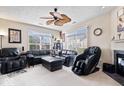 Bright living room featuring a ceiling fan, large windows, and a comfortable leather couch at 7236 Wyatt Ln, Indianapolis, IN 46217