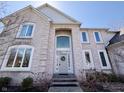 Elegant brick home featuring a welcoming entryway with large windows and a classic front door with wreath at 9921 N Wind River Run, McCordsville, IN 46055