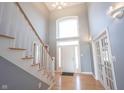 Grand foyer with soaring ceilings, hardwood floors, and a striking staircase leading to the upper level at 9921 N Wind River Run, McCordsville, IN 46055