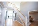 Bright foyer featuring a staircase with white railings and wood floors, leading to the upper level at 9921 N Wind River Run, McCordsville, IN 46055