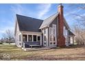 Charming home showcasing a brick chimney and a screened porch with a bench seat at 10249 Southwind Dr, Indianapolis, IN 46256